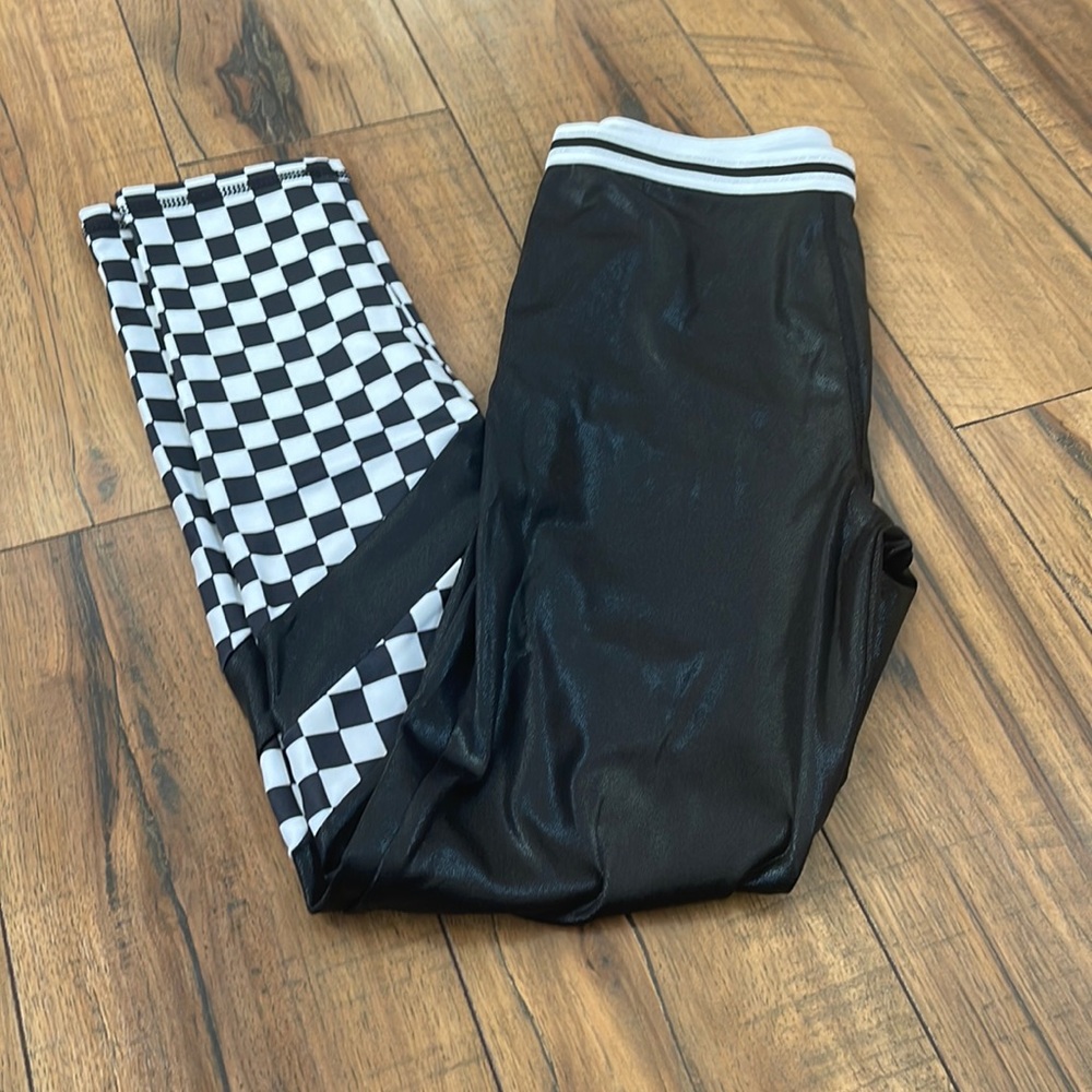 Girls black leggings with black and white checkered pattern on lower half.